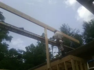 Carpenter setting a ridge beam over a new addition frame — Ice Dam Removal by Roofing Brothers in Oakes