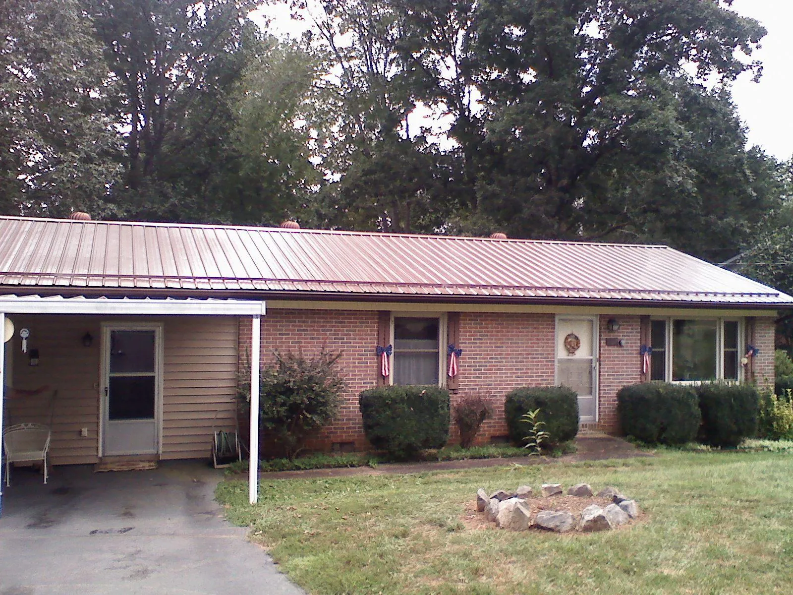 Bronze metal roof and carport on a brick ranch home — Roof Repair work by our crew in Oakes