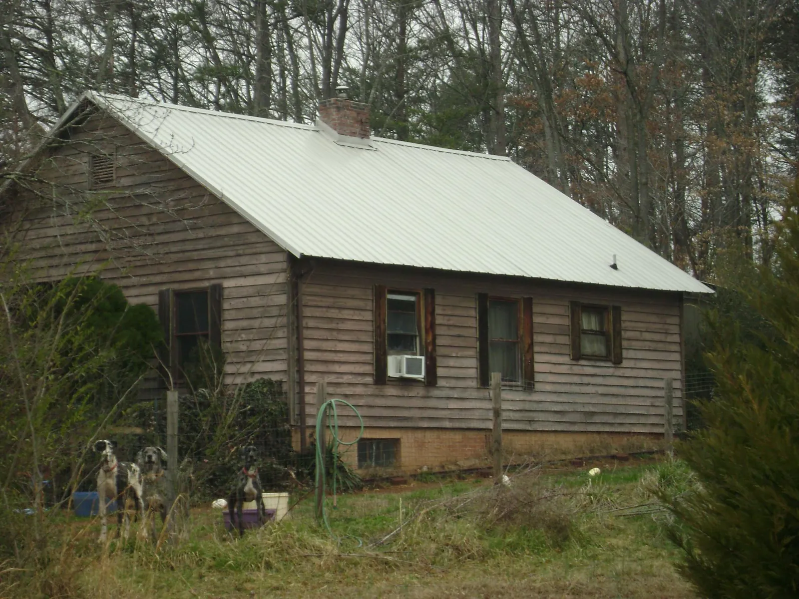 White metal roof on an old wood sided farmhouse, from a Metal Roof Installation job in Oakes